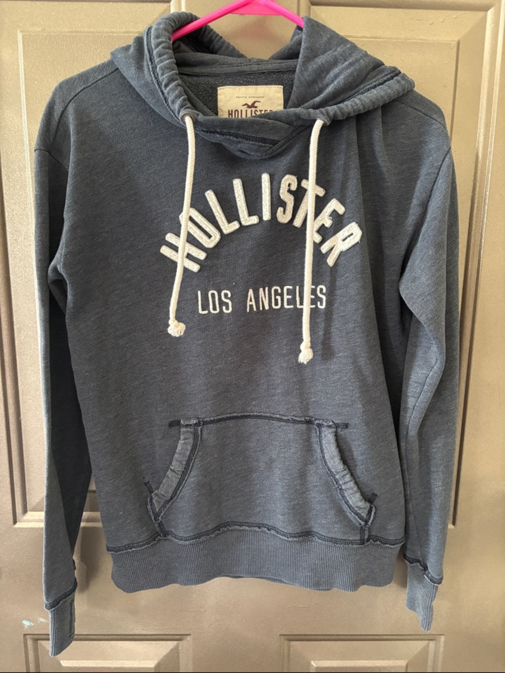 Hollister Cream Tag with Maroon Logo on Dark Gray Fabric